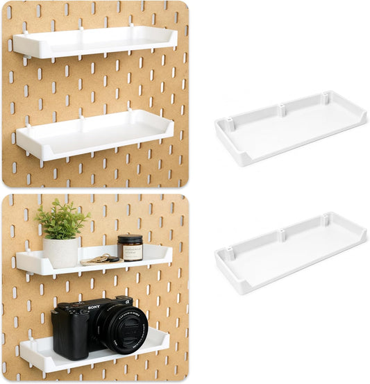 Two white pegboard shelves mounted with a plant, keys and camera