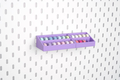 Purple 10-slot and 14-slot sewing bobbin holders mounted together on an IKEA SKÅDIS pegboard