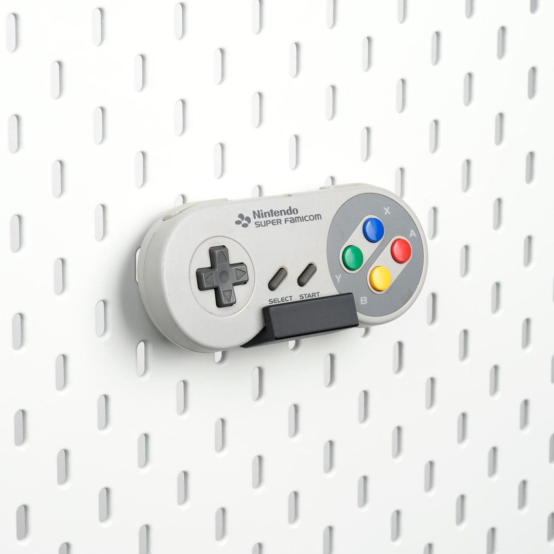 Pure Black SNES and Super Famicom controller holder mounted on an IKEA SKÅDIS pegboard