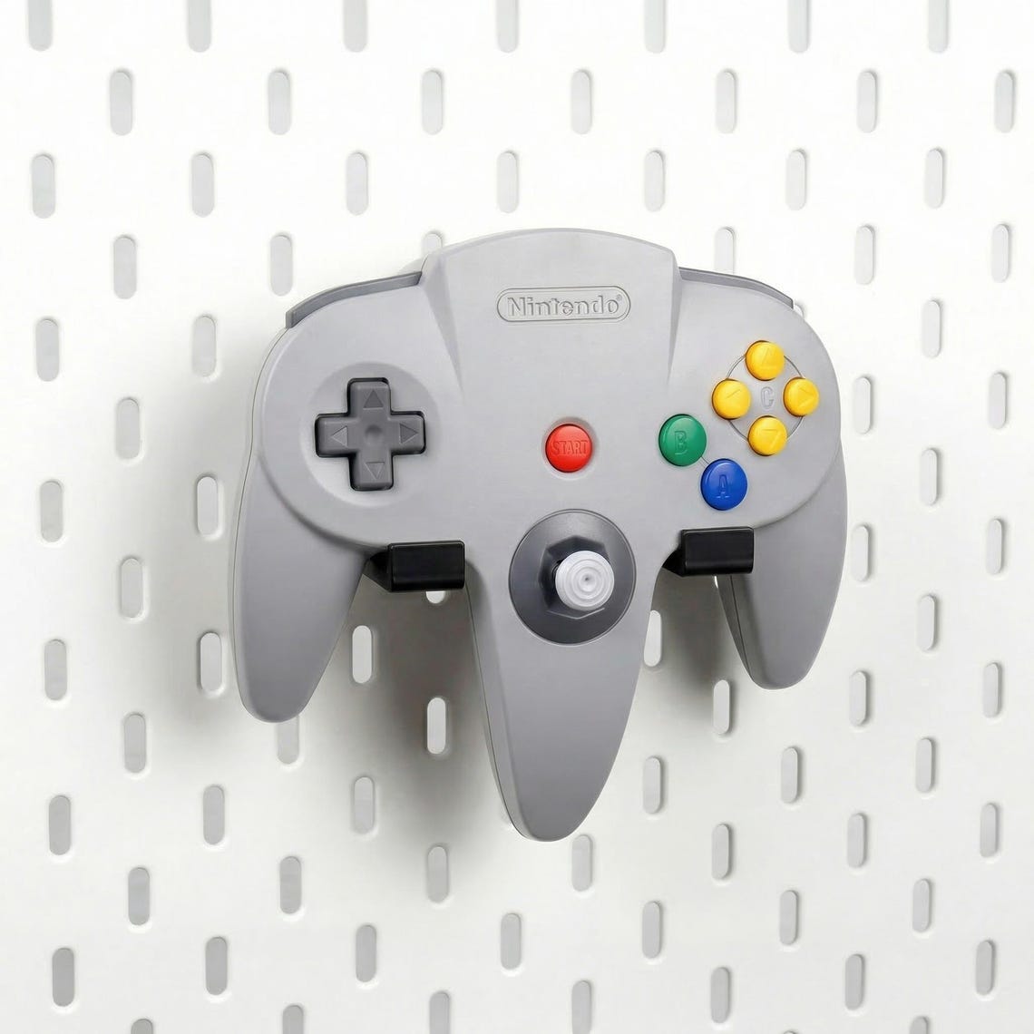 Pure Black Nintendo 64 controller holder mounted on an IKEA SKÅDIS pegboard