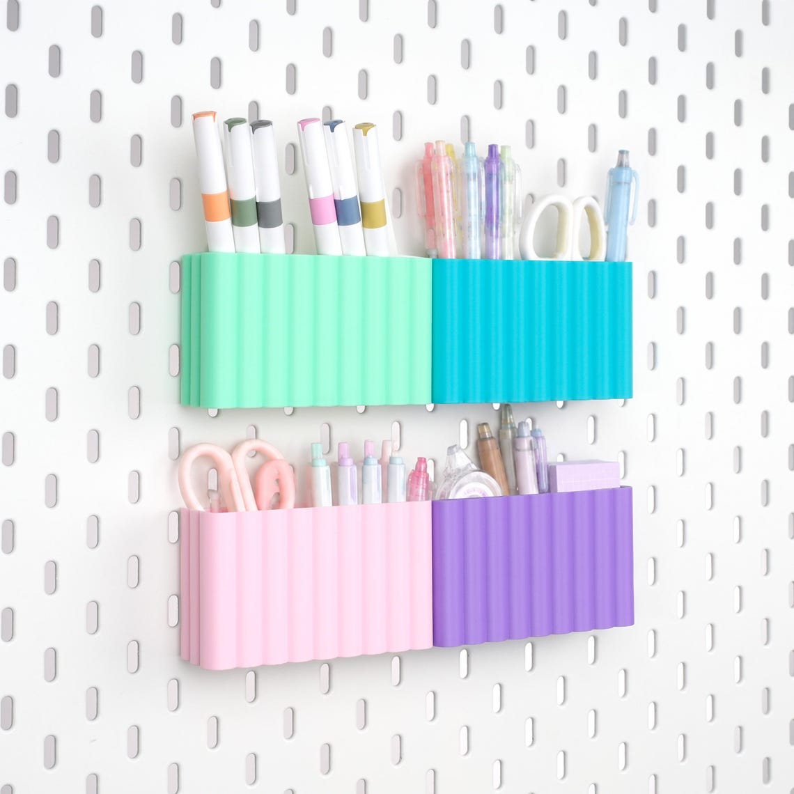Four Wave M pegboard pen holders in mint, turquoise, pink and purple on IKEA SKÅDIS