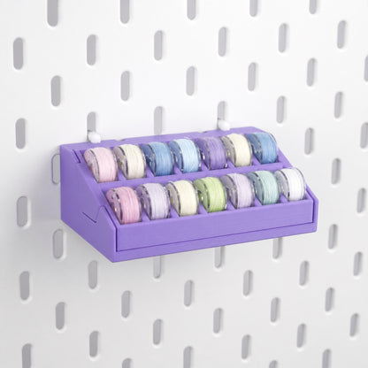 Purple 14-slot removable bobbin organizer mounted on a white pegboard