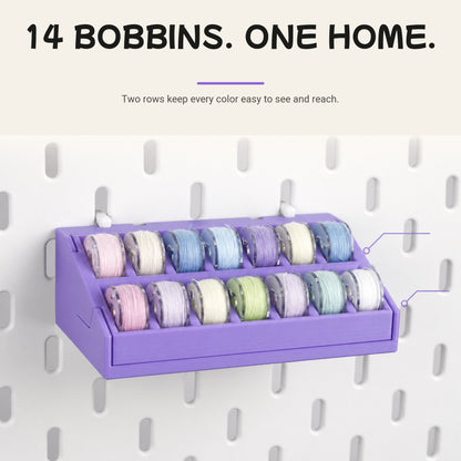 Pegboard bobbin organizer holding 14 sewing bobbins in two visible rows