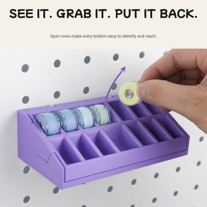Hand removing a sewing bobbin from the open 14-slot organizer