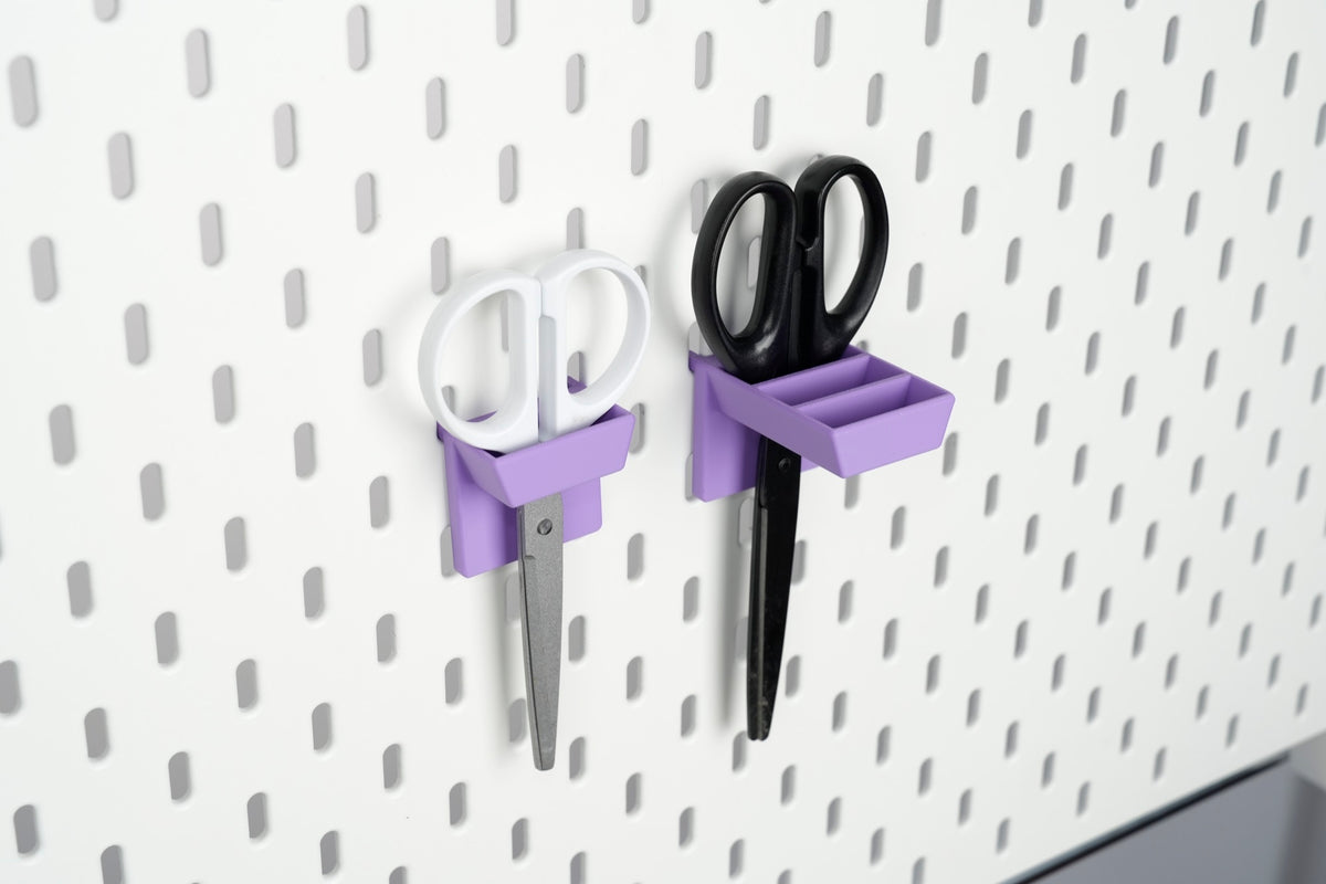 Single-slot and three-slot purple scissors holders mounted on a white IKEA SKÅDIS pegboard