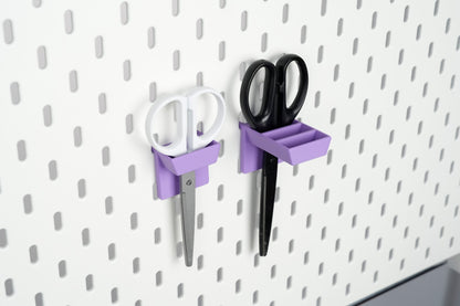 Single-slot and three-slot purple scissors holders mounted on a white IKEA SKÅDIS pegboard