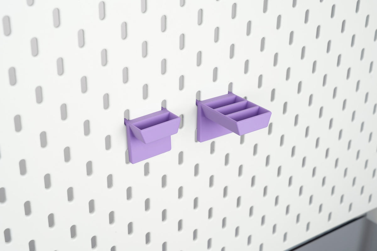 Purple single-slot and three-slot pegboard scissors holders shown empty on IKEA SKÅDIS