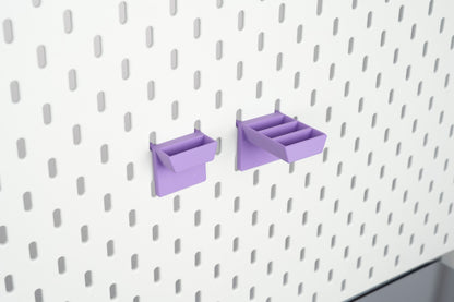 Purple single-slot and three-slot pegboard scissors holders shown empty on IKEA SKÅDIS